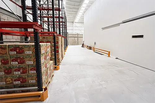 Interior de un almacén de alimentos de grado alimenticio con cajas de productos en estanterías.